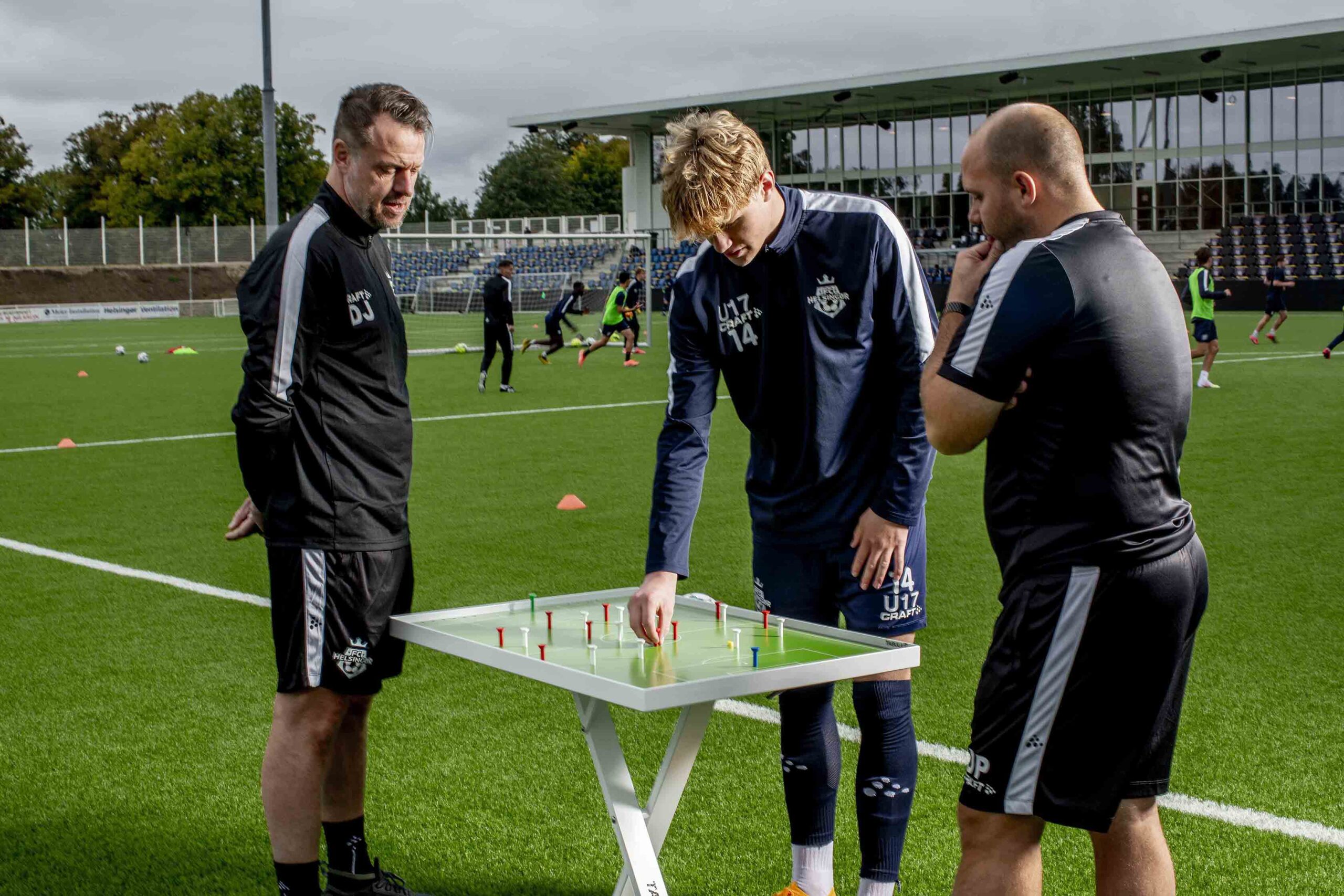 Coaches and player with Tabula1 on the pitch